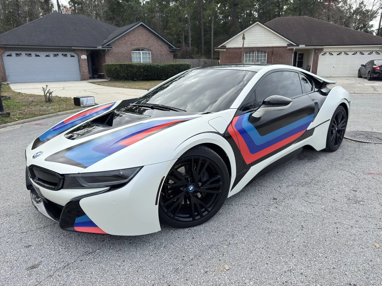 BMW i8 wrapped in white with blue and red racing stripes