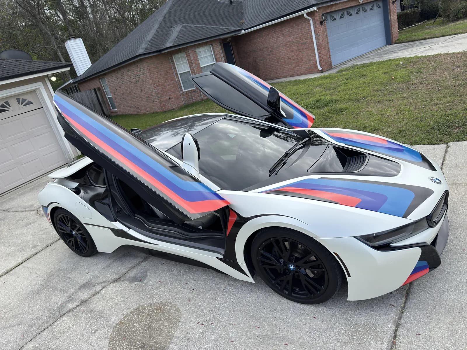 BMW i8 with the doors open, showing the wrapped panels