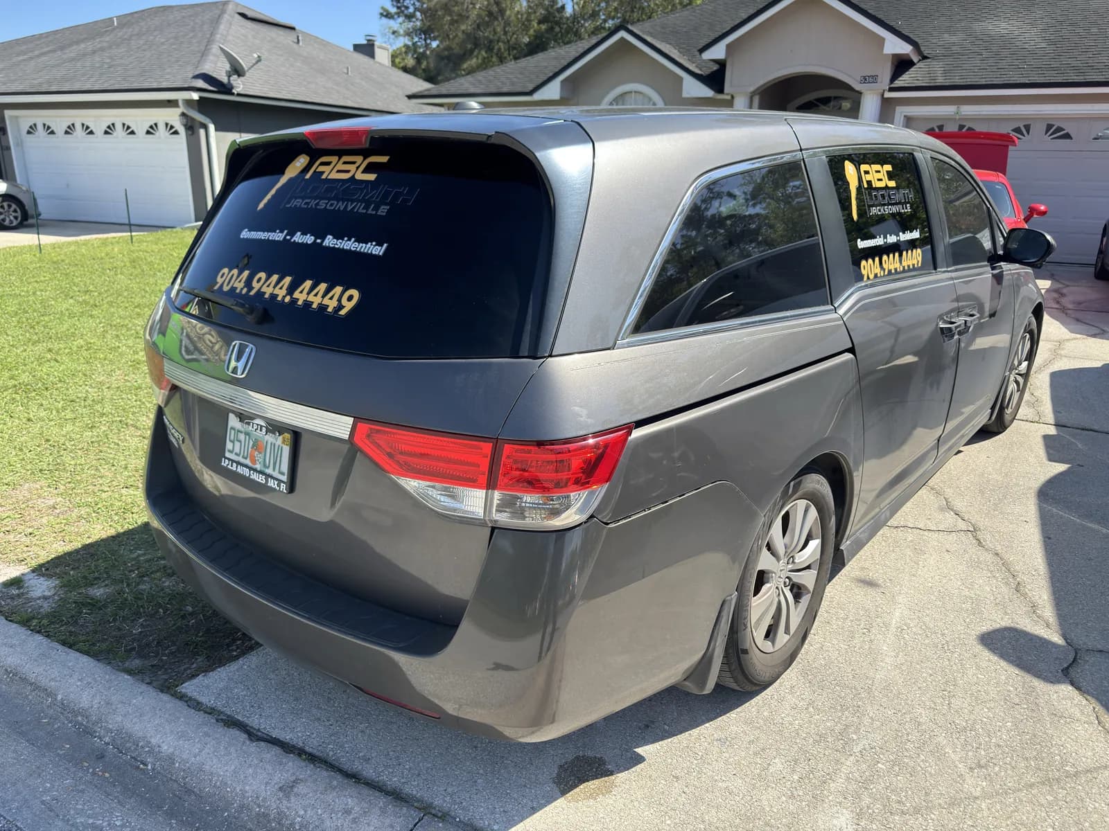 Minivan with rear window and door decals for a locksmith