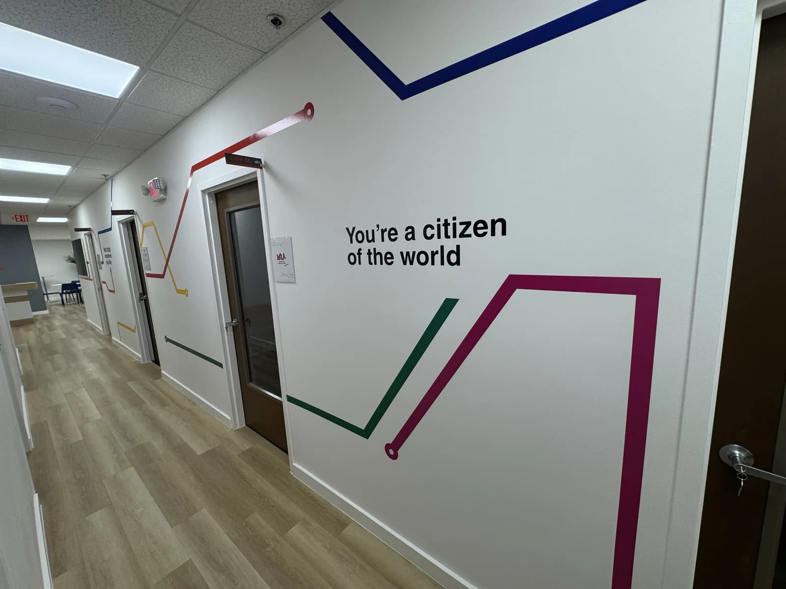 Hallway wall graphics with coloured lines and a quote