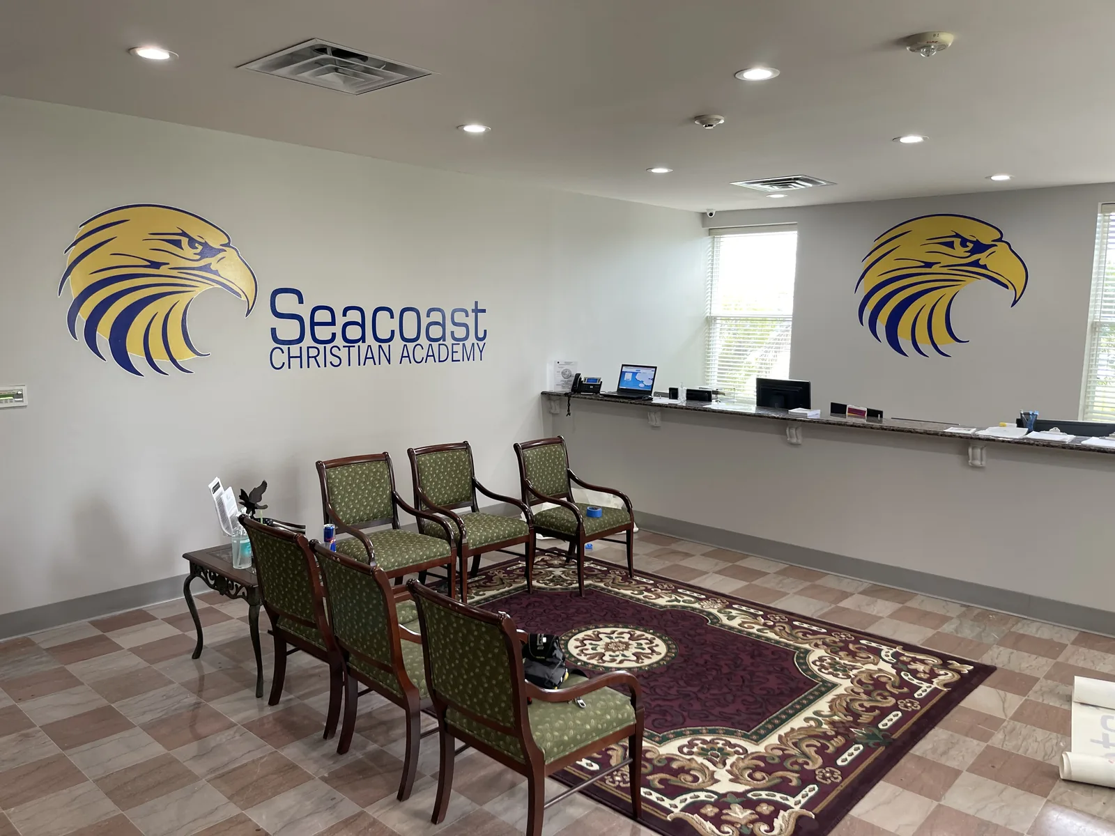 Reception wall with a school logo printed across it