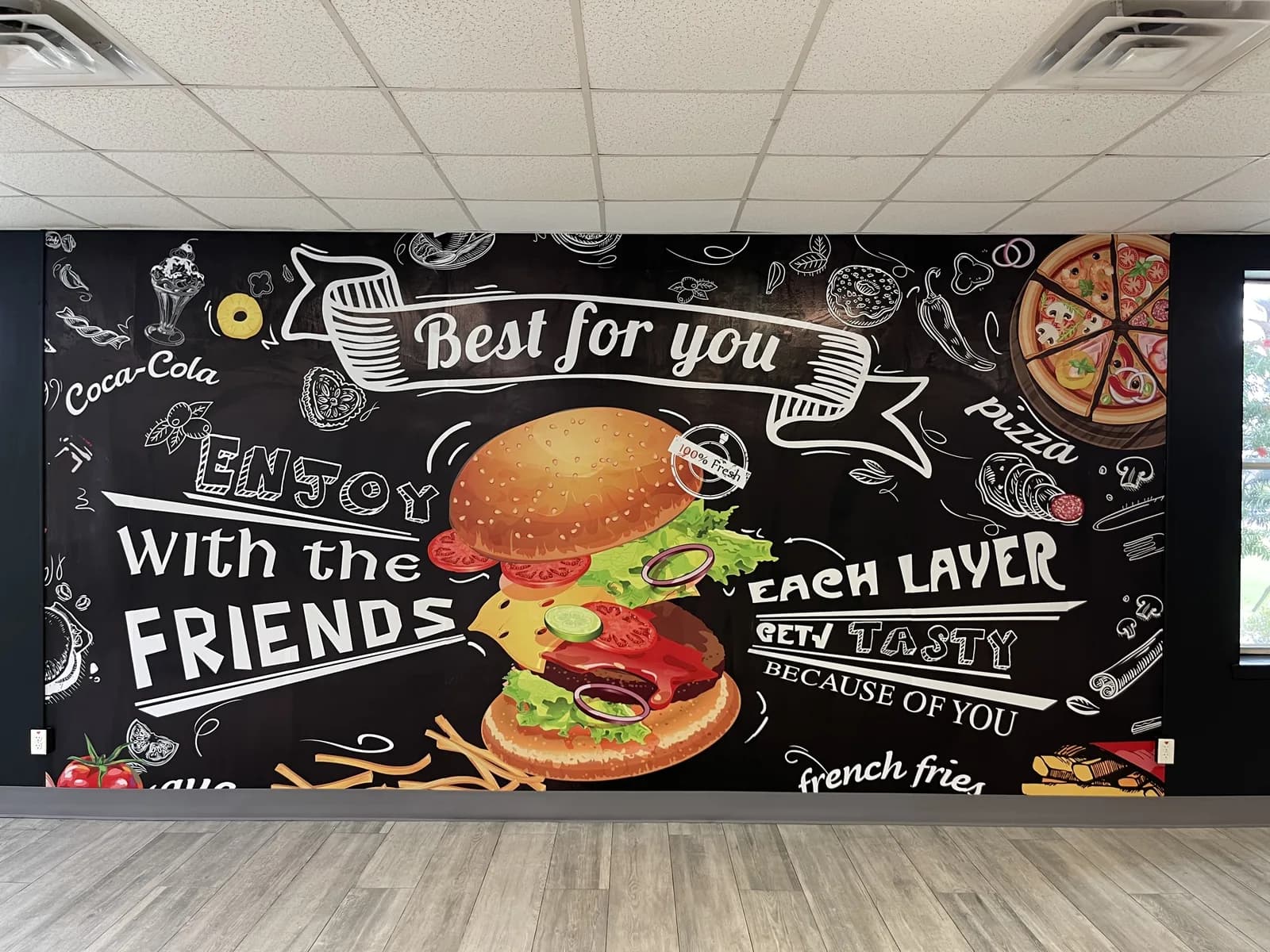 Restaurant wall printed as a chalkboard menu mural with burgers and pizza