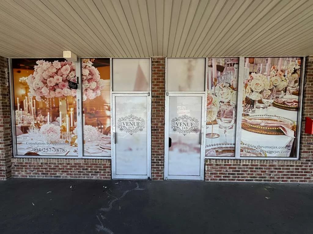 Event venue storefront with printed window panels showing floral and wedding artwork